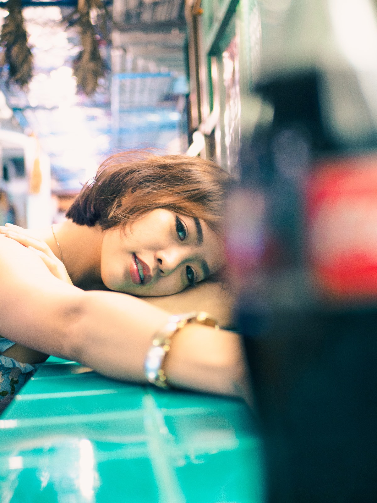 A short hair girl looking directly into the camera while laying on a vintage table.